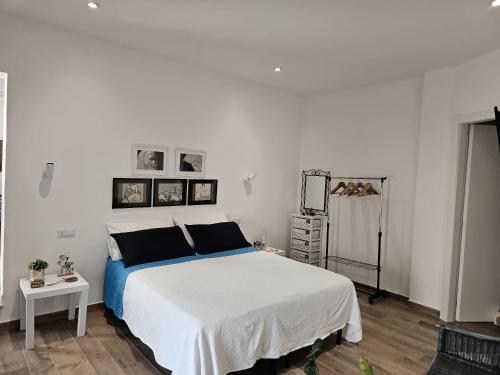 a bedroom with a large white bed and a table at Rose e fiori in Teulada