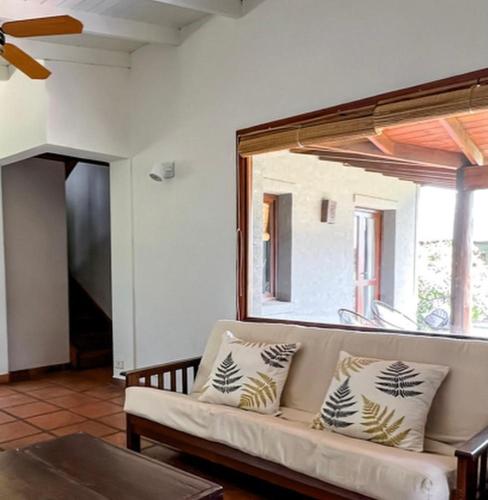a living room with a couch and a large window at Refugio En Las Sierras in Tandil