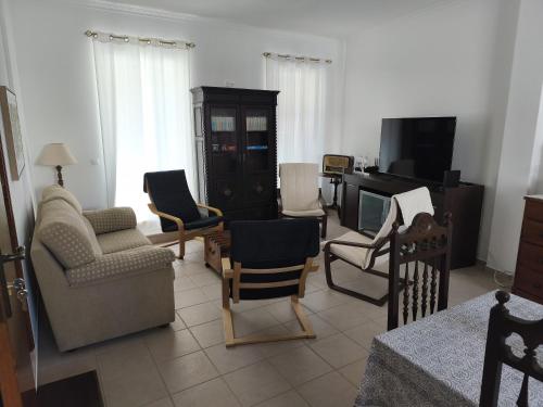 ein Wohnzimmer mit Stühlen und einem Fernseher in der Unterkunft Praca e Canto in Amoreira