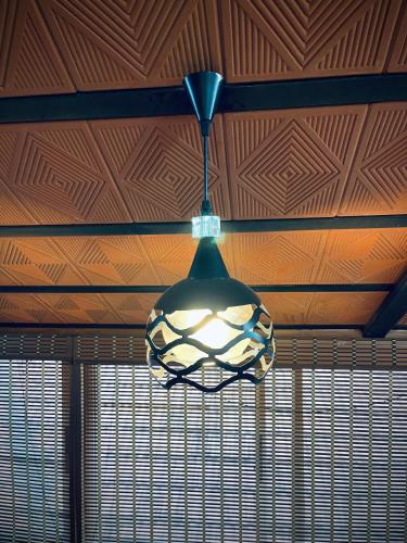 a light hanging from a ceiling in a room at Wood House Near Isha And Karunya University by Shivalaya in Alāndurai
