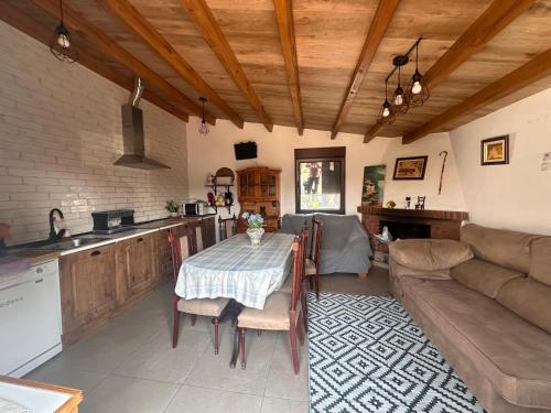 een keuken en woonkamer met een tafel en een bank bij Casa campo de 3 habitaciones con parcela in Villamayor