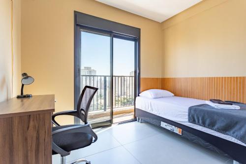 a bedroom with a bed and a desk and a window at Apt Novo 20º Andar, Perto de Tudo! in Goiânia