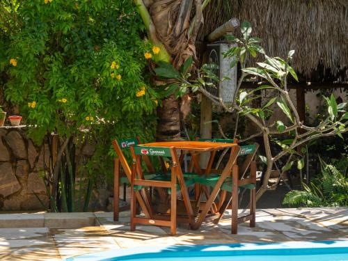 a table and chairs sitting next to a pool at Casa de hóspedes Balibar Cumbuco in Cumbuco