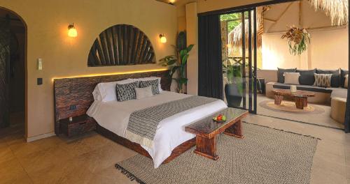 a bedroom with a large bed and a living room at Hotel Casa Candela in San Jerónimo
