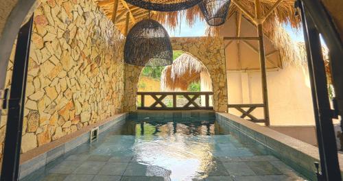 a swimming pool in a house with a stone wall at Hotel Casa Candela in San Jerónimo