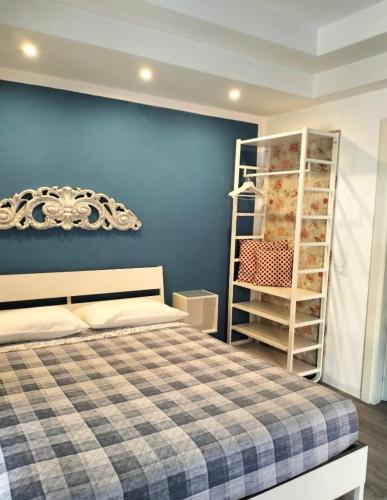 a bedroom with a bed and a blue wall at Chez Nous in La Spezia