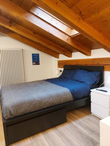 a bed in a room with wooden ceilings at Maison du bois in Torgnon