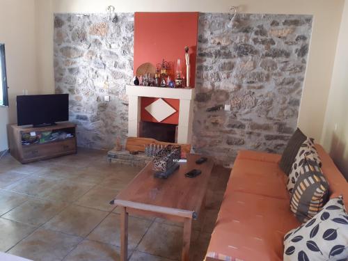 a living room with a couch and a fireplace at MOMENTS of HAPPINESS in Soúrpi