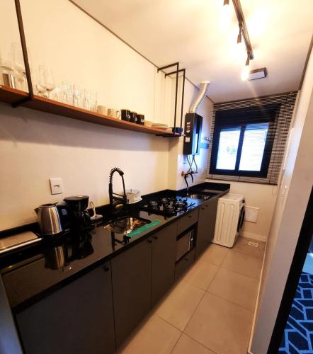 a kitchen with a sink and a counter top at Studio 703 Premium no Centro de Chapecó com Sacada Piscina Academia e Vaga Garagem in Chapecó