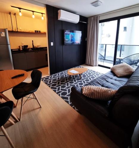 a living room with a couch and a table at Studio 703 Premium no Centro de Chapecó com Sacada Piscina Academia e Vaga Garagem in Chapecó