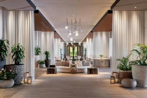 a lobby with white furniture and potted plants at The Ritz-Carlton O'ahu, Turtle Bay in Kahuku