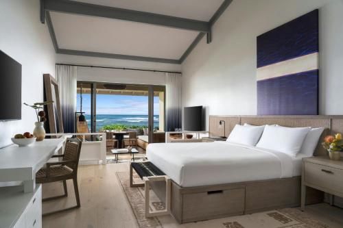 a bedroom with a large bed and a living room at The Ritz-Carlton O'ahu, Turtle Bay in Kahuku