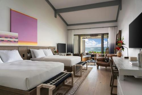 a hotel room with two beds and a living room at The Ritz-Carlton O'ahu, Turtle Bay in Kahuku