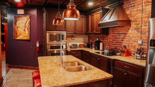 a kitchen with a sink and a brick wall at Broadway 4br 2bth 2500sf Art Gallery and Steam Room in Nashville