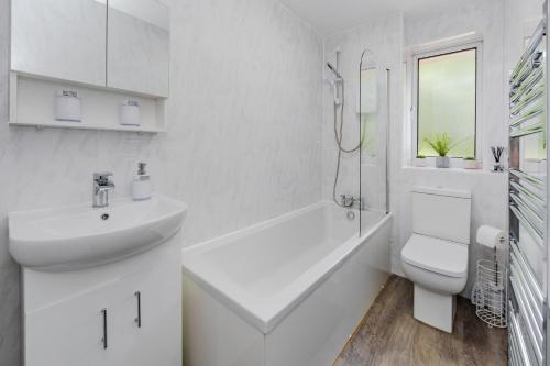a white bathroom with a sink and a toilet at Lovely 2 Bedroom House in Cheshunt