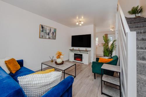 a living room with a blue couch and a fireplace at Lovely 2 Bedroom House in Cheshunt