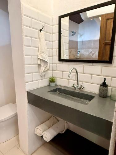 a bathroom with a sink and a mirror at Passion For Surfing Apt Playa Guiones in Playa Guiones