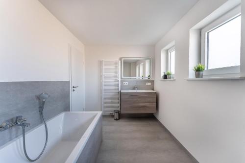 ein weißes Badezimmer mit Badewanne und Waschbecken in der Unterkunft Komfortable Unterkunft für Monteure und Reisende - zentrale Lage, volle Ausstattung, fairer Preis - SCH05 in Schramberg