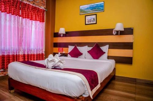 a bedroom with a large bed with red and white pillows at hotel pokhara manaslu in Pokhara