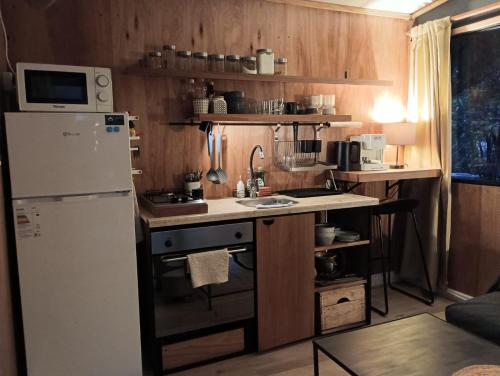 eine kleine Küche mit einem weißen Kühlschrank und einer Theke in der Unterkunft Cuatro estaciones - Casa en PuntaNegra in Barra de Portezuelo