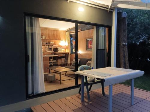 ein Esstisch auf einer Terrasse mit Blick auf eine Küche in der Unterkunft Cuatro estaciones - Casa en PuntaNegra in Barra de Portezuelo