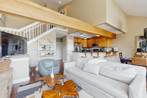 a living room with a white couch and a kitchen at Beaver Creek Bungalow in Edwards