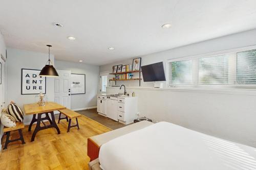 a bedroom with a bed and a table and a kitchen at Beaver Creek Bungalow in Edwards