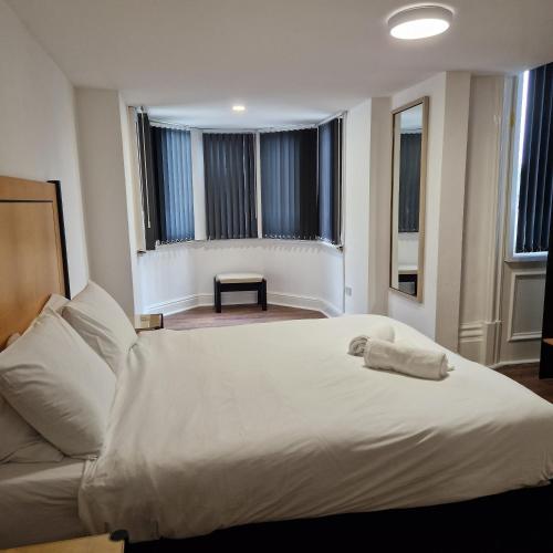 a bedroom with a white bed and a couch at The Dorchester Hotel & serviced apartments in Hull