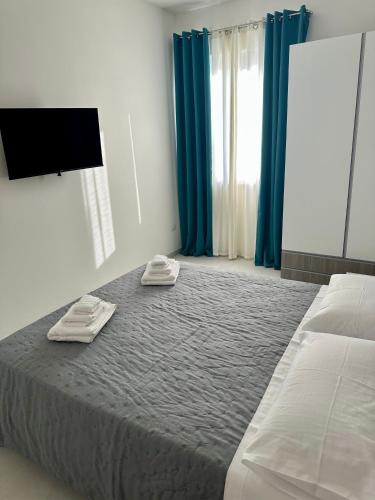 a bedroom with a large bed with blue curtains at Levante Apartments in Torrenova