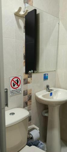 a bathroom with a toilet and a sink and a mirror at HOTEL QUILICHAO in Santander de Quilichao