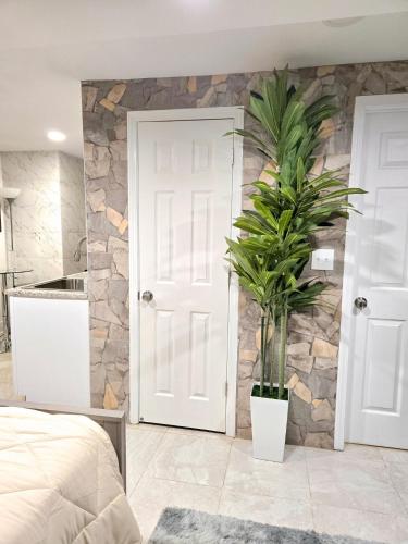 a bedroom with a white door and a plant at Vessel Hotel Studio Suites of Atlanta, GA in Atlanta