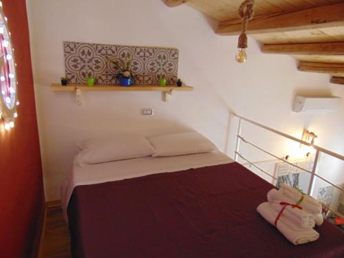 a bedroom with a bed with a shelf on the wall at Vicolo San Paolo in Palazzolo Acreide