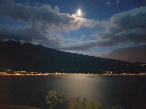 a view of a lake at night with the moon at Residence Erika in Tignale