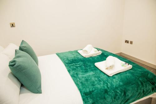 a bed with two towels on top of it at Cosy 1 Bedroom Apartment in Central Blackburn in Blackburn