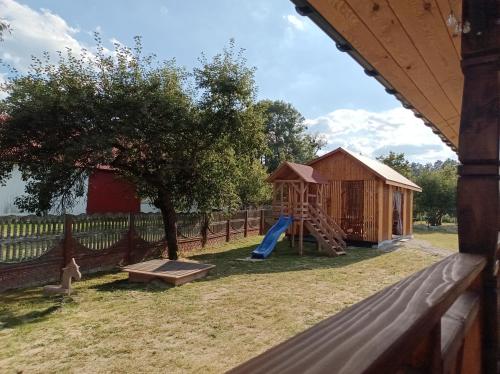 a playground with a slide and a play house at Zielone Rykowisko - Myśliwski domek całoroczny in Blizów