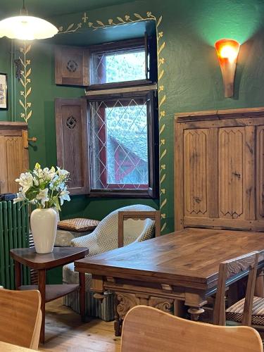 a dining room with a wooden table and a window at Le Manoir des Remparts de Besse in Besse-et-Saint-Anastaise