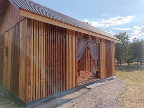 a wooden building with a deck with a drape at Zielone Rykowisko - Myśliwski domek całoroczny in Blizów