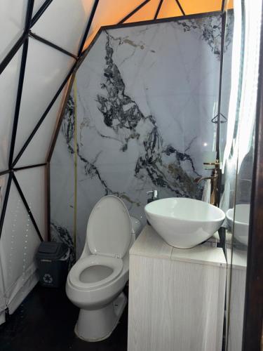 a bathroom with a toilet and a sink in a tent at El Refugio Glamping in Choachí
