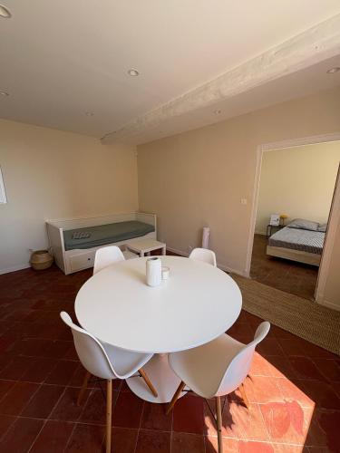 a white table and chairs in a room with a bed at Charmant 2 pièces avec vue Mer au coeur du village in Cagnes-sur-Mer