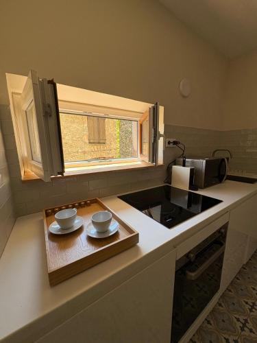 a kitchen counter with two plates and a window at Charmant 2 pièces avec vue Mer au coeur du village in Cagnes-sur-Mer