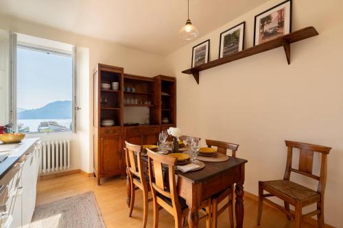 a dining room with a table and chairs and a kitchen at Terrace Over Torno - by MyHomeInComo in Torno