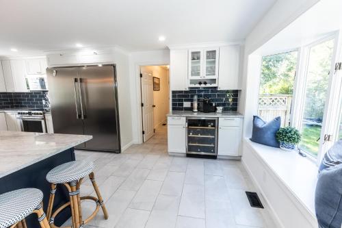 a kitchen with white cabinets and a large window at Rare Cape Cod Find in Brewster