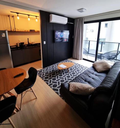 a living room with a couch and a table at Studio 703 Premium no Centro de Chapecó com Sacada Piscina Academia e Vaga Garagem in Chapecó