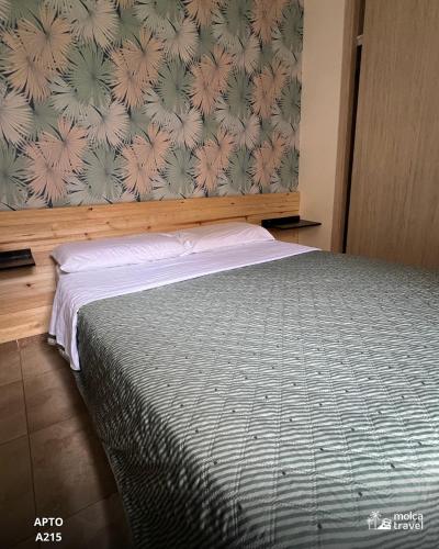 a bedroom with a bed with a floral wallpaper at Alojamiento Familiar para 21 - A 5min del Aeropuerto - Con 4 Pisincas - 3 Jacuzzi - By Molca Travel in Armenia