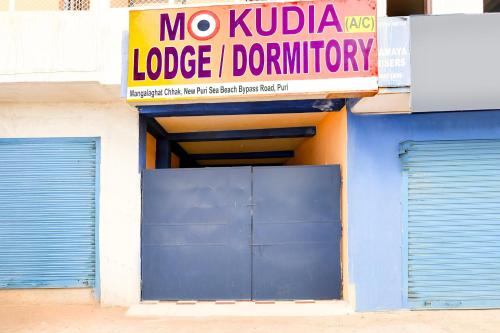 a no kloppka lodgeinion sign above a garage door at OYO Flagship Hotel O Mo Kudia in Puri