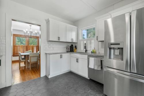 a kitchen with white cabinets and a stainless steel refrigerator at 3 Bed 1 5 Bath Home in College Hill By Hospital in Wichita
