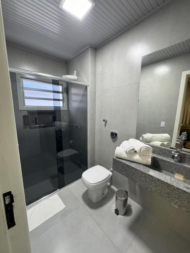a bathroom with a toilet and a shower and a sink at Rio Jordao Hotel in Siderópolis