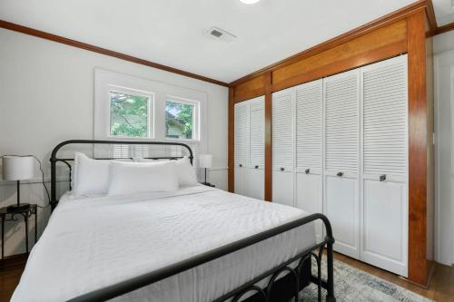 a bedroom with a bed with white bedding and white cabinets at 3 Bed 1 5 Bath Home in College Hill By Hospital in Wichita
