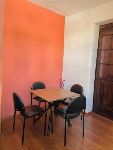 a table and chairs in a room with an orange wall at TRAVELER'S HOUSE QUITO in Quito