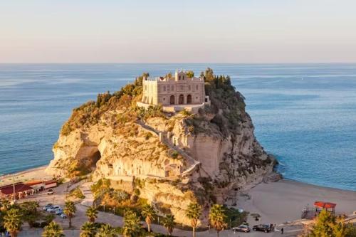 a building on top of a cliff next to the ocean at B&B Salty Mermaid in Tropea